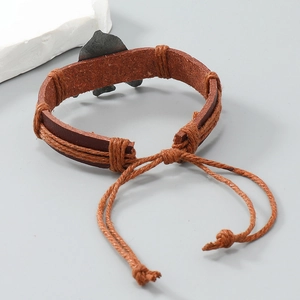 Detail of vintage braided leather bracelet with adjustable cord and fish charm