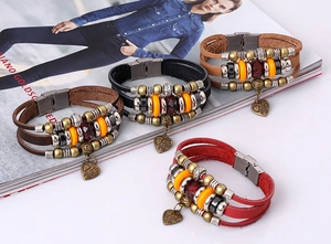 Detail of vintage multilayer leather bracelets with heart pendant and brass beads