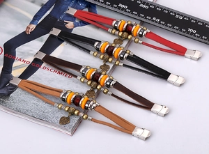 Detail of ethnic leather beaded bracelets in four colors with heart charm and metal clasp