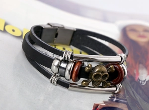 Macro view of multi-layer leather bracelet with bronze skull charm and mixed beads