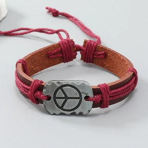 Macro di un bracciale in pelle fatto a mano con placca in metallo del simbolo della pace
