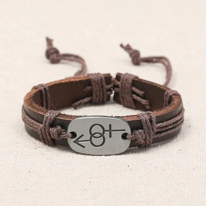Vintage braided brown leather bracelet with metal gender symbol on a linen background