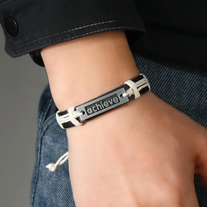 Men's hand-woven black leather bracelet featuring a silver zinc alloy 'achieve' nameplate