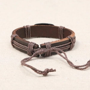 Retro woven brown leather bracelet with adjustable rope closure on burlap background