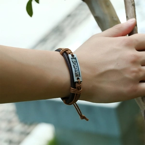 Detail eines handgewebten Lederarmbands mit antiker Silberplatte und Kordelzug