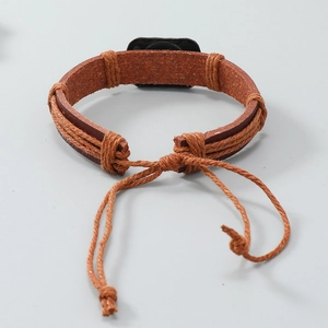 Dettaglio del bracciale in pelle intrecciata regolabile con placca in metallo vintage