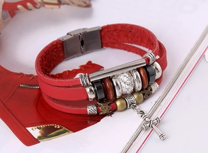Détail d'un bracelet en cuir rouge multicouche avec pendentif croix et perles