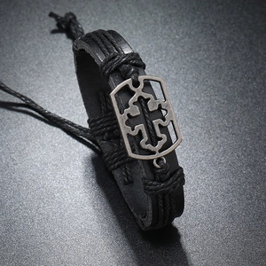 Makro-Detail von schwarzem geflochtenem Lederarmband für Herren mit Vintage-Silberkreuz