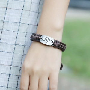 Close-up of vintage braided leather bracelet with engraved male and female symbols