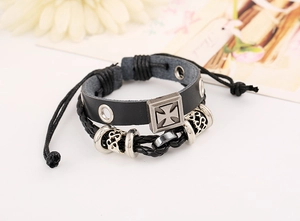 Macro shot of multi-layer leather bracelet with metallic cross and punk style details