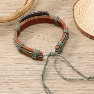 Close-up of handmade woven flower leather bracelet with adjustable drawstring closure