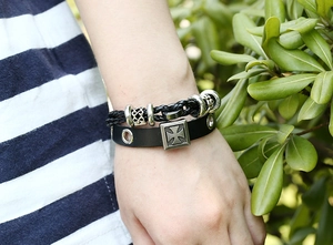 Close-up of vintage punk leather bracelets with metal beads and Maltese cross detail