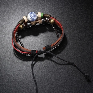Macro view of vintage multi-layer leather bracelet with blue ceramic flower bead detail