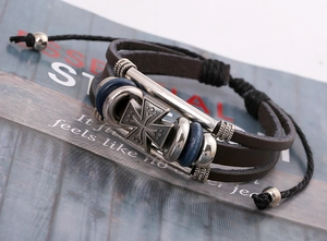 Detail eines mehrlagigen Lederarmbands mit Sternenkreuz und blauen Perlen auf Magazin