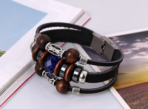 Detail of multilayer leather bracelet featuring blue gemstone and vintage wooden beads