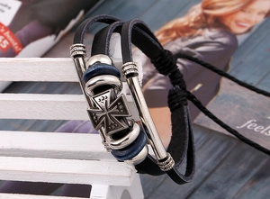 Makroaufnahme von Lederarmband mit blauen Perlen und Vintage-Kreuzanhänger in Lagen