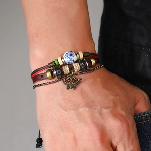 Detail of multi-layer leather bracelet with vintage bronze butterfly charm and beads