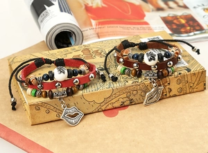 Detail of layered leather bracelets with bohemian wood beads and leaf charms