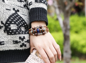 Detail view of multilayer vintage leather bracelet with wooden beads and blue accent gem