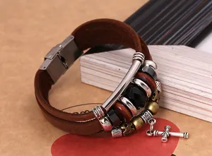 Macro shot of multi-layer brown leather bracelet with silver cross pendant and beads