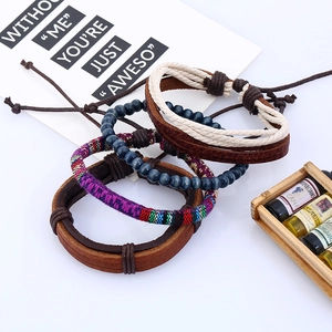 Detailed close-up of 4-piece vintage leather bracelets with braided beads and ethnic patterns