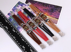 Detail view of multi-layered braided leather bracelets with iron cross metal charms