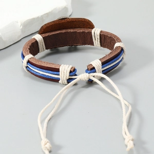 Detail of handmade brown leather bracelet with blue cotton cord and adjustable knot
