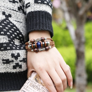 Bohemian multilayer leather bracelet with wooden beads and blue crystal in soft outdoor light