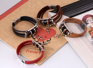 Detail of multi-layer leather bracelets with cross pendant and stainless steel clasp