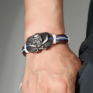 Handmade leather pirate skull bracelet with crossed swords on a braided cord strap