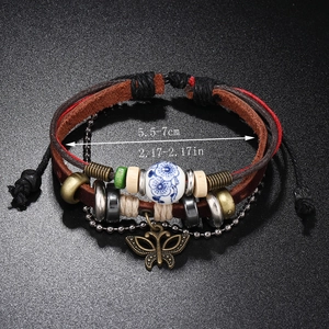Handmade multilayer leather bracelet with beads and butterfly pendant on black background