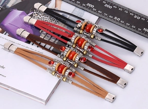 Macro shot of multilayer leather bracelets with red gemstones and metallic vintage beads