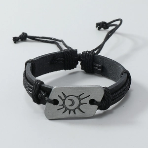 Détail du bracelet en cuir tressé avec motif soleil et lune sur plaque en métal