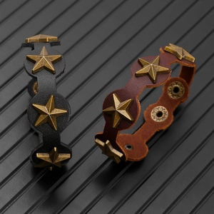 Gros plan de bracelets punk en cuir avec clous étoiles en bronze et boutons-pression