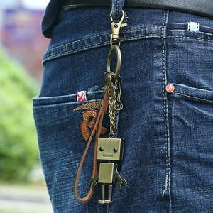 Porte-clés robot vintage en bronze avec lanière en cuir sur passant de jean