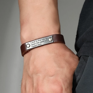 Handmade brown leather bracelet with an engraved inspirational metal plaque on wrist