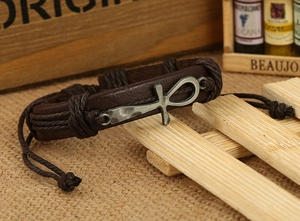 Detailed close-up of brown braided leather bracelet with vintage silver Ankh charm