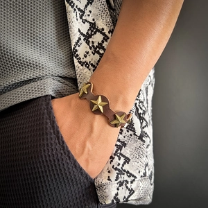 Gros plan d'un bracelet en cuir punk avec clous en étoile portés au poignet