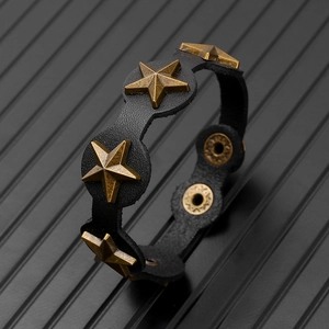 Détail d'un bracelet punk en cuir avec clous en étoile bronze et bouton pression ajustable