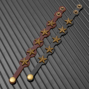 Détail de bracelets punk en cuir avec rivets étoiles vintage et fermoir à bouton pression