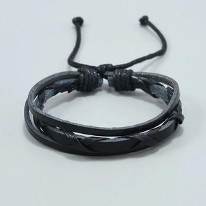 Detail of multi-layer hand-woven black leather bracelet with adjustable drawstring closure