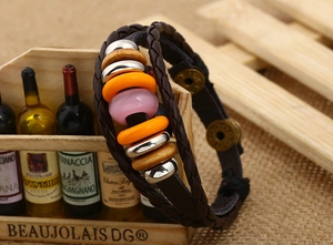 Detail of multi-layer woven leather bracelet with vintage wooden beads and metal accents