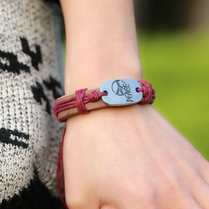 Handmade woven leather bracelet with vintage metal plate featuring Peace engraving