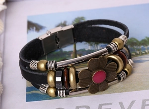 Detailed close-up of retro multi-layer leather bracelet with bronze beads and floral charm
