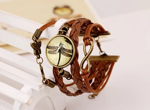 Detail of vintage multilayer braided leather bracelet with dragonfly and infinity charms