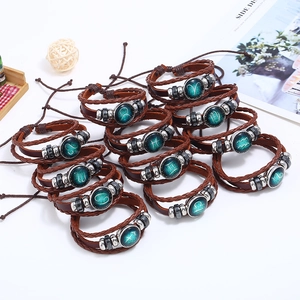 Detail of vintage braided leather zodiac bracelets with glass cabochon constellation charms