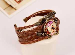 Macro shot of multilayer leather bracelet with bronze butterfly and infinity charm detail