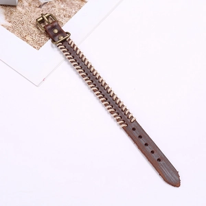 Detail of vintage brown leather woven bracelet featuring white stitching and buckle
