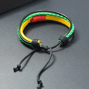 Detail of woven Rasta style leather bracelet featuring green, red, and yellow cord layers