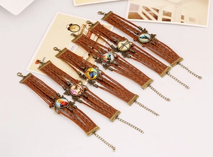 Detail of vintage multilayer braided leather bracelets with dragonfly and butterfly charms